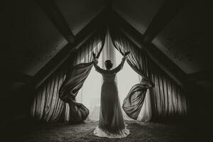 a noiva dentro uma Casamento vestir abre a cortinas, espalhando dela mãos foto