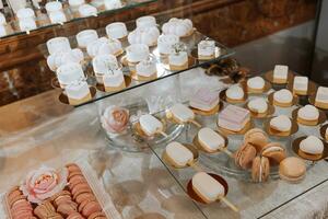 festivo sobremesa mesa com doces. Casamento doce bar, vários bolos, chocolates em fica. foto