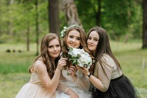 Casamento andar dentro a floresta. noivas e seus amigos pose contra a fundo do a floresta. uma ampla grupo do pessoas estão tendo Diversão às seus amigos' Casamento foto