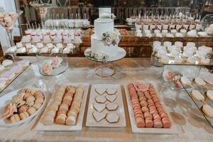 festivo sobremesa mesa com doces. Casamento doce bar, vários bolos, chocolates em fica. foto