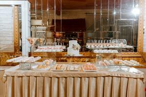 festivo sobremesa mesa com doces. Casamento doce bar, vários bolos, chocolates em fica. foto