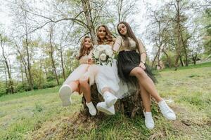 Casamento andar dentro a floresta. noivas e seus amigos pose contra a fundo do a floresta. uma ampla grupo do pessoas estão tendo Diversão às seus amigos' Casamento foto