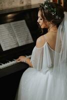 retrato do uma lindo menina dentro uma Casamento vestir e uma guirlanda do fresco flores em dela cabeça, jogando a piano, jogando sozinho foto