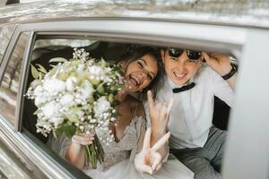 jovem feliz noiva e noivo estão alegria depois de a Casamento cerimônia dentro seus carro foto