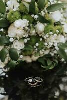 Casamento ramalhete dentro uma verde estilo do diferente flores em uma Preto fundo, dentro a primeiro plano do uma Casamento anel foto