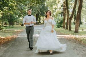 uma Casamento casal, uma feliz noiva e noivo estão corrida dentro a parque para a Lugar, colocar do a Casamento cerimônia. Casamento conceito foto