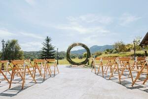 a Casamento arco dentro a parque é fez do seco palhetas em a fundo do a floresta dentro borrado foco. longe Casamento cerimônia. decorado cadeiras para a cerimônia foto