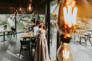 lado Visão retrato do uma rindo europeu casal desfrutando uma encontro dentro uma cafeteria com suspensão retro lâmpadas foto