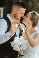 jovem lindo Casamento casal romanticamente abraçando e desfrutando seus Casamento dia segurando Casamento argolas em seus dedos foto