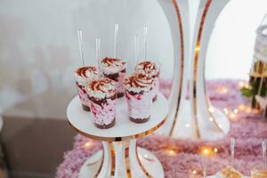 festivo sobremesa mesa com doces. Casamento doce bar, vários bolos, chocolates em fica. foto