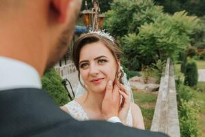 uma Casamento casal é desfrutando a melhor dia do seus vida contra a fundo do verde folhas dentro a parque. retrato do noivas dentro amor dentro natureza foto