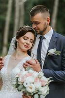 uma Casamento casal é desfrutando a melhor dia do seus vidas contra a pano de fundo do alta árvores retrato do noivas dentro amor dentro natureza foto