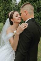 noivo e noiva se beijando dentro a parque. uma casal do recém-casados, a noiva e noivo, às uma Casamento dentro natureza, uma verde floresta, se beijando, foto retrato. Casamento casal