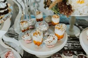 uma delicioso casamento. branco bolo decorado com flores doce Barra para uma banquete. celebração conceito. elegante sobremesas. mesa com doces, doces. frutas foto