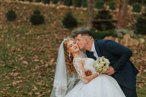 retrato do a elegante Casamento casal ternamente abraçando dentro uma floresta ou parque. luxo noiva e noivo abraçando. romântico sensual momento foto