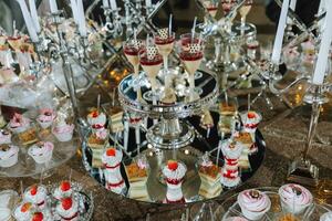 uma doce mesa às uma casamento. mesa com bolos e doces às a festival. aniversário doces foto