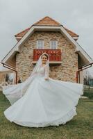 retrato do uma lindo noiva com uma vôo véu dentro uma volumoso Casamento vestir e profissional inventar. a noiva rotaciona dentro dela vestir foto