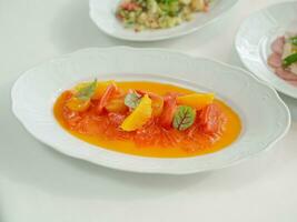 salmão salada com laranja e manjericão dentro branco prato em branco mesa foto