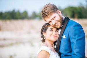 Noiva asiática e noivo caucasiano têm tempo de romance e felizes juntos foto