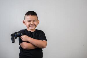 menino feliz jogando computador com um controlador em estúdio foto