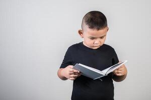 menino engraçado lendo um livro foto