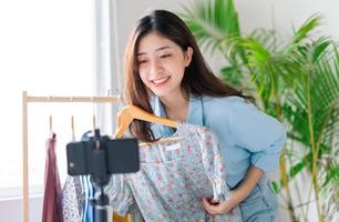 retrato de uma jovem mulher de negócios que está transmitindo roupas ao vivo foto