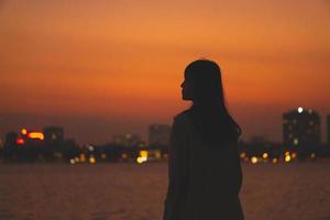 retrato de silhueta de menina e lindo pôr do sol foto