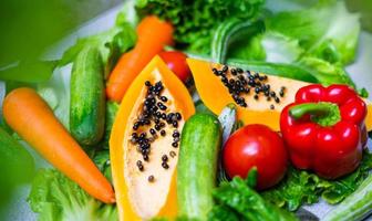 opções de alimentos saudáveis para comer limpo, frutas, vegetais, sementes, vegetais com folhas em concreto cinza foto