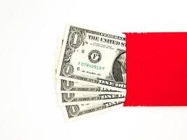 envelope vermelho isolado no fundo branco com dinheiro do dólar para o presente ano novo chinês. texto chinês no envelope significa feliz ano novo chinês foto