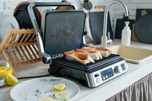 fresco truta bife pronto ser cozinhou em elétrico grade dentro a cozinha foto