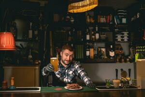 amigáveis sorridente bartender Fora vidro do não filtrado Cerveja dentro bar foto