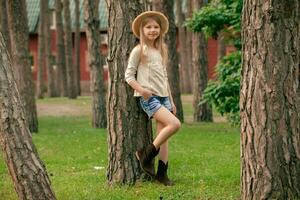sorridente interpolação menina inclinado contra alta árvore dentro pátio do país casa dentro verão foto