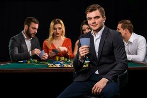 jovem pessoas jogando pôquer às a mesa. cassino foto