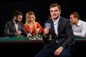 jovem pessoas jogando pôquer às a mesa. cassino foto