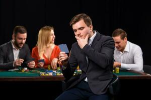 jovem pessoas jogando pôquer às a mesa. cassino foto