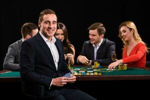 jovem pessoas jogando pôquer às a mesa. cassino foto