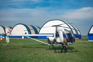 pré-adolescente menina dentro oculos de sol em pé perto helicóptero dentro vôo campo foto