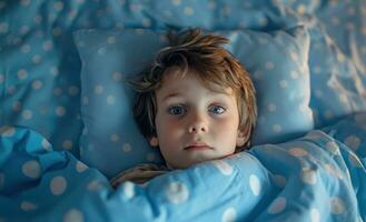 ai gerado uma pequeno Garoto deitado dentro cama com azul e branco almofadas por aí dele cabeça foto