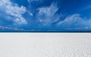 praia de areia branca com nuvens. foto