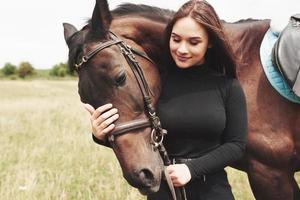 uma garota feliz se comunica com seu cavalo favorito. a menina adora animais e passeios a cavalo
