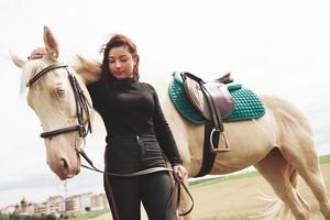 uma garota feliz se comunica com seu cavalo favorito. a menina adora animais e passeios a cavalo foto