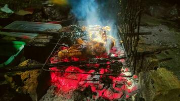 grelhado frango sobre quente carvão às noite foto