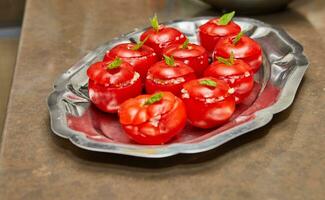 arranjo do recheado tomates com fresco hortelã folhas em metal bandeja dentro cozinha foto