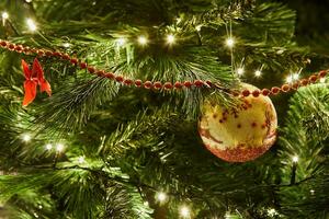 fechar-se do Natal árvore com enfeites e festão com luzes foto