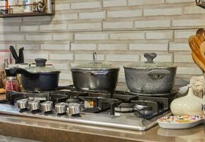 ocupado cozinha cena com potes, tampas, e gás fogão cozinhando Comida às casa foto