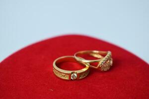 fechar acima dourado anel com diamante em vermelho tapete fundo foto