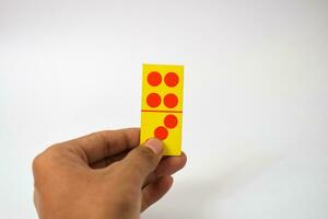 mão aguarde dominó jogando cartões isolado branco fundo, amarelo vermelho dominó cartões foto