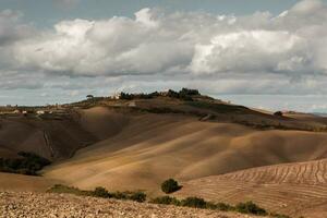 colhido Campos e prados panorama dentro toscana, Itália. ondulado país cenário às outono pôr do sol. arável terra pronto para a agrícola temporada. foto