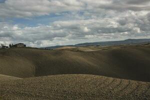 colhido Campos e prados panorama dentro toscana, Itália. ondulado país cenário às outono pôr do sol. arável terra pronto para a agrícola temporada. foto