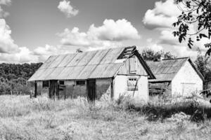 linda e velha casa de fazenda abandonada na zona rural em fundo natural foto